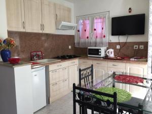 a kitchen with white cabinets and a table and a microwave at les alicantes in Coursan +16 photos