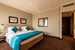 a bedroom with a large bed with a blue blanket at Terme di Relilax Boutique Hotel & Spa - Adults Only in Montegrotto Terme