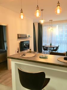 Il comprend une cuisine et un salon avec une table et des chaises. dans l'établissement Adams Apartment Onix Blue, à Mamaia Nord – Năvodari
