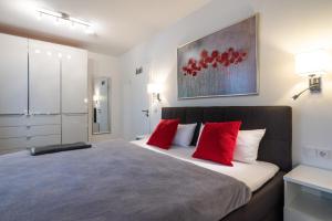 ein Schlafzimmer mit einem großen Bett mit roten Kissen in der Unterkunft Appartement "Karat" mit Penthouseflair - Oase am Haff in Garz