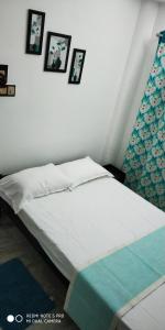 łóżko w sypialni z obrazami na ścianie w obiekcie Andoor Homes, Apt No 2B w mieście Thiruvananthapuram