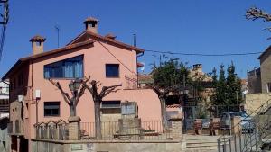 a pink house with trees in front of it at turismo rural del somontano (Alquiler de apartamentos) in Salas Bajas