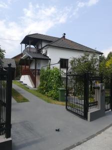 Uma casa branca com um portão à frente. em Holiday Home Baotic em Velika Mlaka