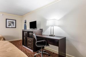 a hotel room with a desk with a computer and a lamp at Quality Inn Forrest City I-40 in Forrest City