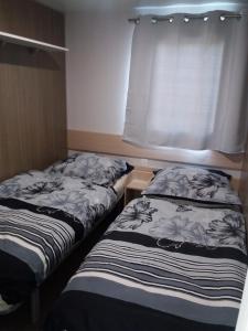 2 camas en una habitación pequeña con ventana en Seacottage Blankenberge - Wenduine, en De Haan