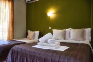 una camera d'albergo con due letti e asciugamani di Hotel Barracuda a Sárti