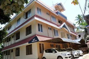 un edificio con coches estacionados frente a él en Andoor Homes, Apt No 2B, en Trivandrum