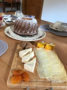 a table with a cutting board with cheese and a cake at Chambres d'hôtes Maison Efftermatten in Andlau