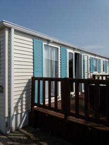 a mobile home with a wooden deck at Seacottage Blankenberge - Wenduine in De Haan