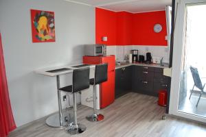 ヒルデスハイムにあるFerienwohnung Am Steinbergのキッチン(赤いキャビネット、赤い冷蔵庫付)