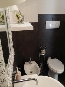 a bathroom with a white toilet and a sink at Casa Mireio in Modica