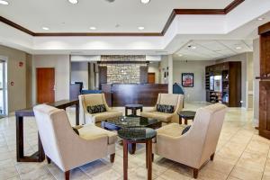 a lobby with a waiting area with chairs and a table at Canalta Hotel Assiniboia in Assiniboia