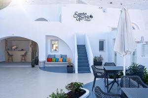 a patio with chairs and a table with a umbrella at Santoterra Antigua Suites in Karterados