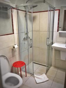 a shower with a red stool in a bathroom at Pensiunea Margareta in Alba Iulia
