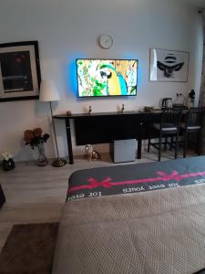 uma sala de estar com televisão na parede em Room Lux SPA " TABARKA " em Spa