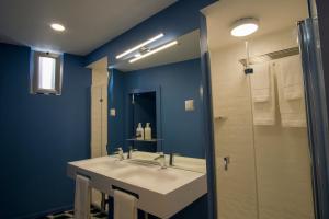 a bathroom with a white sink and a shower at ZIGZAG HOSTEL in Praia da Vitória
