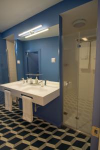 a bathroom with a white sink and a shower at ZIGZAG HOSTEL in Praia da Vitória