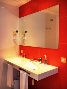 ein Badezimmer mit einem weißen Waschbecken und einem Spiegel in der Unterkunft Hotel del Juguete in Ibi