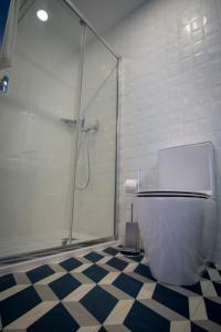 a bathroom with a shower and a white toilet at ZIGZAG HOSTEL in Praia da Vitória