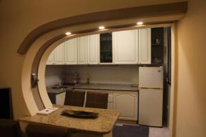 a kitchen with white cabinets and a white refrigerator at Apartment No 5 in Prishtinë