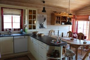 a kitchen with a sink and a table in a room at Solberg 10 persons cabin in Myro