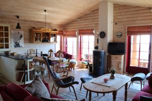cocina y sala de estar con mesa y sillas en Solberg 10 persons cabin, en Myro