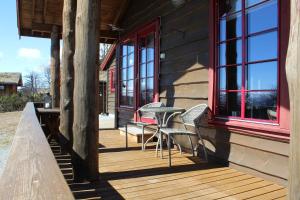 una terraza de madera con sillas y una mesa en una casa en Solberg 10 persons cabin, en Myro