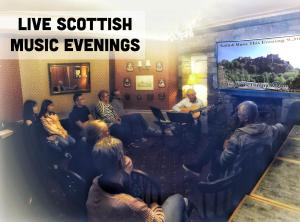 un grupo de personas sentadas en una habitación viendo una película en Averon Guest House, en Edimburgo