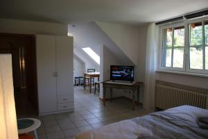 a bedroom with a bed and a desk with a computer at Wein Lodge Durbach - Schlossblick in Durbach