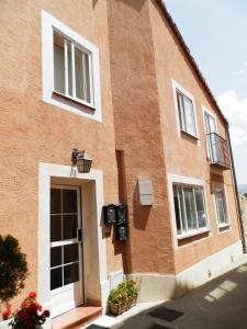 un edificio de ladrillo rojo con puerta y ventanas en LA CORRALA, en Segovia