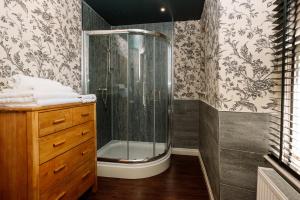 a bathroom with a shower and a wooden dresser at The Rectory Rooms, Studio 2 in Threshfield
