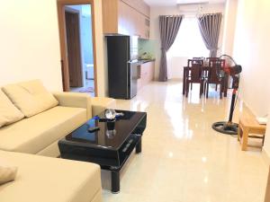 a living room with a couch and a table at My Khe beach apartment hotel, 2 bedrooms in Da Nang