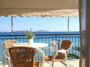 a table and chairs on a balcony with the ocean at Artemis in Tolo