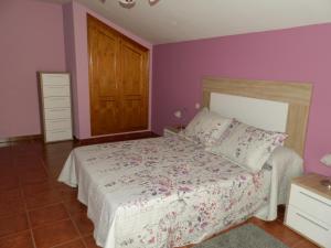 una camera da letto con un letto con pareti viola e una porta in legno di LA CORRALA a Segovia