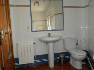 Un baño con lavabo, inodoro y espejo. en LA CORRALA, en Segovia
