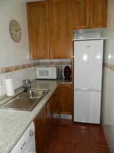 una cucina con frigorifero bianco e lavandino di LA CORRALA a Segovia