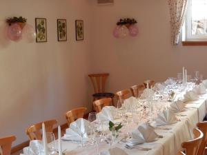 a room with a long table with white plates and glasses at Wein Lodge Durbach - Schlossblick in Durbach