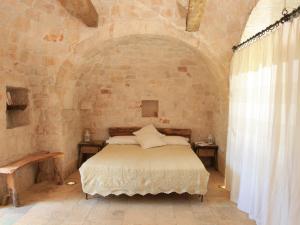a bedroom with a bed in a stone wall at Pietraluce in Alberobello