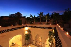 Habitación con vistas a un balcón con luces por la noche. en Riad Infinity Sea, en Marrakech