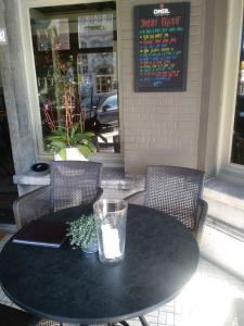 De Verloren Gernoare في دي بان: طاولة سوداء عليها كرسيين وزجاج