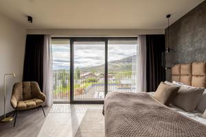 um quarto com uma cama, uma cadeira e uma janela em Hotel Geysir em Geysir