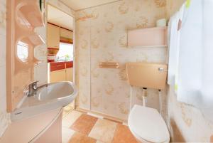 a small bathroom with a toilet and a sink at Domki u Beaty in Rewal +65 photos