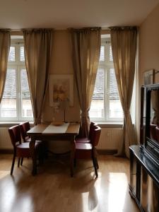 a dining room with a table and chairs and windows at Ferienwohnung Barfly in Traben-Trarbach