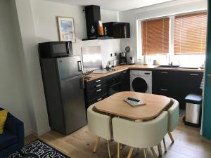 a kitchen with a table and a refrigerator and a sink at Entre mer et commerces in Wimereux
