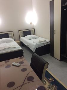 a room with two beds and a table and chairs at Batumi Guesthouse 28a in Batumi