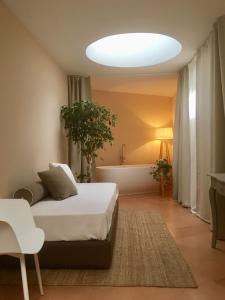 una camera con letto, vasca e lampada di B&B Villino Ada a Pesaro