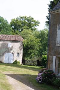 an old stone house with a gate and a yard at DOMAINE de la BORLIERE in Fenioux