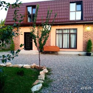 a tree in front of a house with a bench at Tulskiy Pryanik Home in Tul'skiy