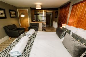 a living room with a large bed and a kitchen at The Rectory Rooms, Studio 3 in Linton
