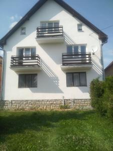 Una casa blanca con balcones en un lateral. en Privát u Ivana en Štrba